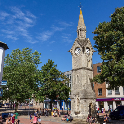 Aylesbury town centre featuring the historic clock tower and busy shopping area on a sunny day.